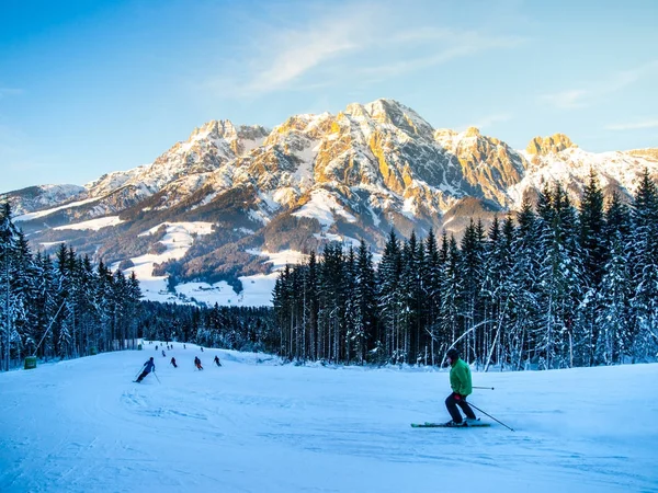 Mensen op ski helling in bergresort op zonnige winterochtend — Stockfoto