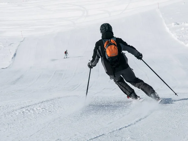 Kayakçı Kayak pisti üzerinde siyah yokuş aşağı Kayak içinde. Arkadan görüntülemek — Stok fotoğraf