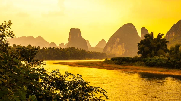 Panorama del atardecer en paisaje kárstico alrededor del río Yangshuo an Li con siluetas de picos, provincia de Guangxi, China — Foto de Stock