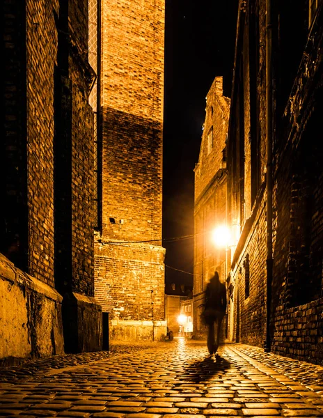 Cobbled street of Old Town with dark blurred silhouette of person. Evokes Jack the Ripper — Stock Photo, Image