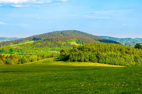 Groene heuvel in het midden van de zonnige lente landschap. Javornik berg in de buurt van Liberec, Tsjechië — Stockfoto