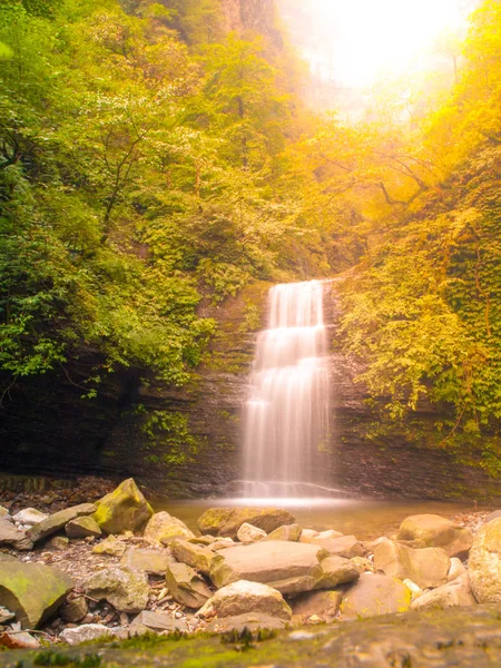 Kleiner romantischer Wasserfall mitten im grünen Wald — Stockfoto
