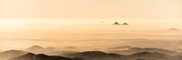 Bezdez montanhas gêmeas subindo da névoa. Inversão da temperatura do tempo, República Checa — Fotografia de Stock