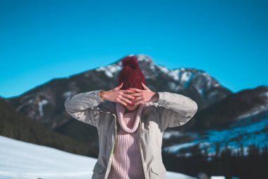 Uzun saçlı ve bereli genç bir kız, güzel bir kış ortamında.