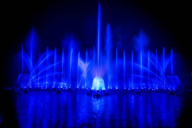 # Yılın kutlaması için dans eden renkli çeşme # # Karanlık gökyüzü arka planıyla #.