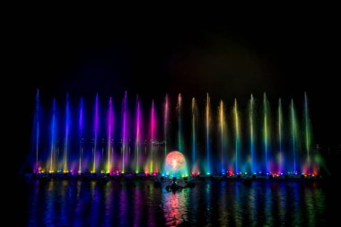 # Yılın kutlaması için dans eden renkli çeşme # # Karanlık gökyüzü arka planıyla #.