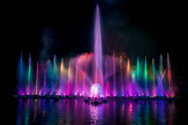 # Yılın kutlaması için dans eden renkli çeşme # # Karanlık gökyüzü arka planıyla #.