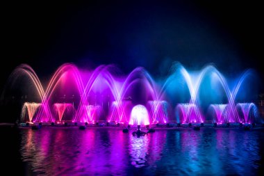 # Yılın kutlaması için dans eden renkli çeşme # # Karanlık gökyüzü arka planıyla #.