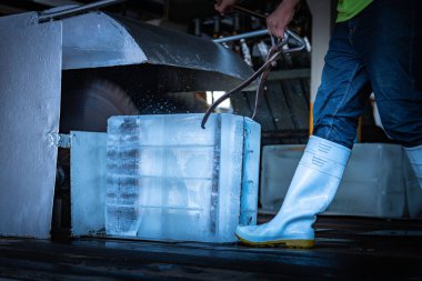 Buz fabrikası, buz fabrikası arka planında ve günışığı ışınları arka planında buz üreten sanayi makinesiyle birlikte çalışıyor..