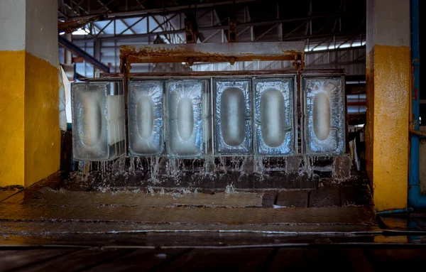 공장에서 공장의 햇빛을 배경으로 얼음을 생산하는 기계와 작업하고 — 스톡 사진