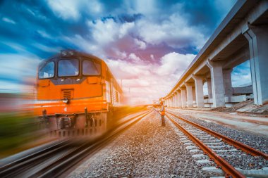 Kıdemli bir mühendis teftiş altında ve inşaat sürecini kontrol ediyor ve tren istasyonu platformunda çalışmalarını kontrol ediyor. İş yerinde güvenlik üniforması ve güvenlik kaskı takan mühendis.