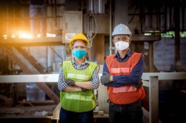 Fabrikadaki kirliliği ve virüsü korumak için güvenlik maskesi takarak, fabrika istasyonunda kontrol altında tutulan kadın ve mühendis portresi..