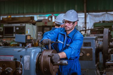 Güvenlik üniforması giyen Endüstri Mühendisliği, endüstri fabrikasında çalışan nesne kontrol işletim makinesini ölçmek için Vernier kalibresini kullandı..