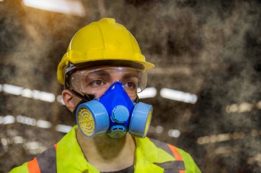 Güvenlik üniforması, siyah eldiven ve gaz maskesi giyen bir mühendis endüstrisi fabrikada kimya deposunu kontrol ediyor..