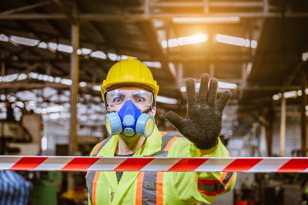 A Engineer industry wearing safety uniform ,black gloves and gas mask show hand signal no entry chemical dangerous area in industry factory work.