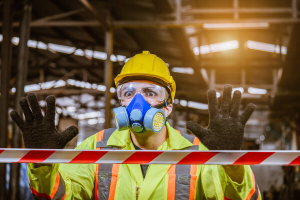 A Engineer industry wearing safety uniform ,black gloves and gas mask show hand signal no entry chemical dangerous area in industry factory work.