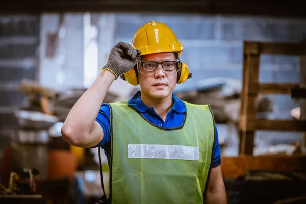 Portrait Industrial engineer wearing safety uniform and safe helmet for work and control machies  with industry factory background.