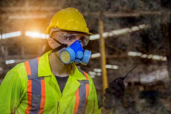 A Engineer industry wearing safety uniform ,black gloves and gas mask under checking chemical tank in industry factory work.