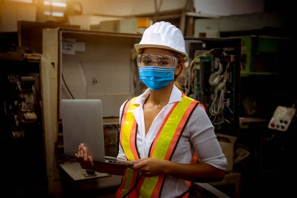 Portrait worker under inspection and checking production process on factory station by wearing safety mask to protect for pollution and virus in factory.