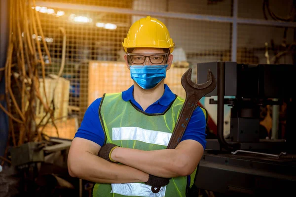 Portrait worker under inspection and checking production process on factory station by wearing safety mask to protect for pollution and virus in factory.