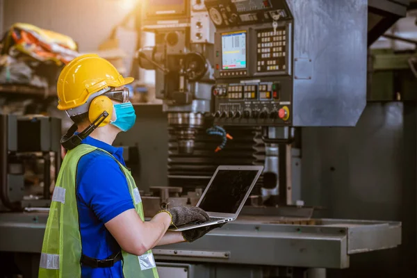 Portrait engineer under inspection and checking production process on factory station by wearing safety mask to protect for pollution and virus in factory.