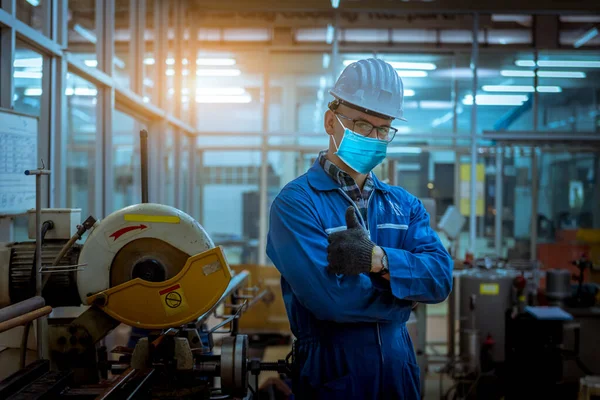 Portrait worker under inspection and checking production process on factory station and safety mask face to protect for pollution and virus in factory.