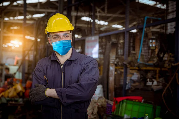 Portrait worker under inspection and checking production process on factory station and safety mask face to protect for pollution and virus in factory.