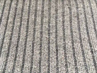 Gri bir kazak içinde kabartmalı kumaş. Soyut arkaplan.