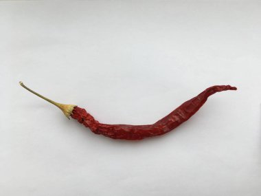 Beyaz arka planda duran uzun kırmızı biber. Soyutlama. Asgari duvar kağıdı.