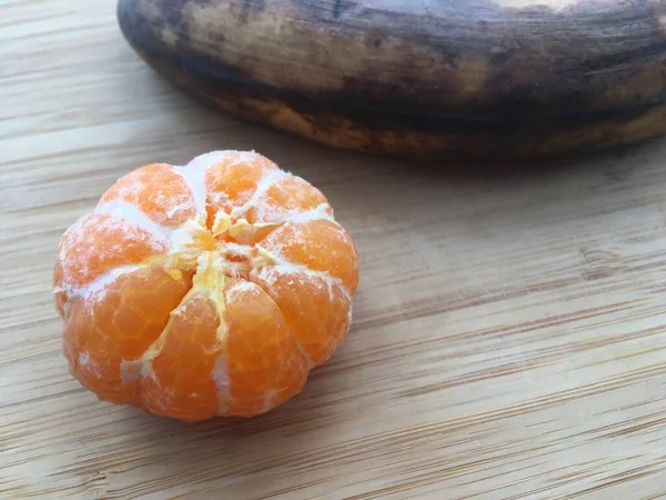 Maturare Frutta Tavolo Legno Mandarino Pelato Banana Non Pelata Scura — Foto Stock