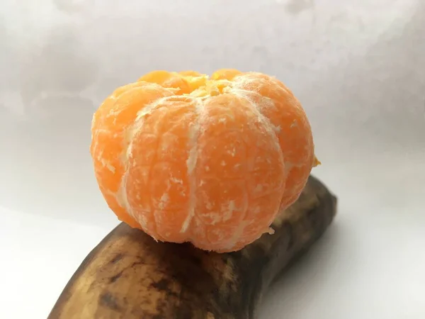 Absztrakt Kompozíció Fehér Háttérrel Meghámozott Mandarin Egy Hámozatlan Banánon Gyümölcsösség — Stock Fotó