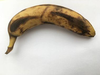 Beyaz arka planda duran büyük, soyulmamış muz. Soyut minimalist duvar kağıdı. Fruitorianizm.