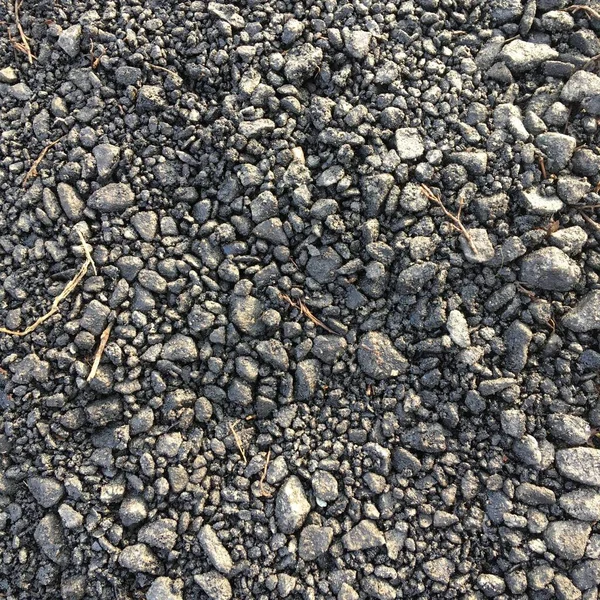 Fine crushed stone of dark gray color. Abstract textural background. Minimalism.