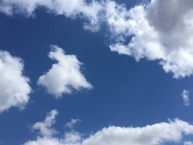 Parlak mavi gökyüzünde beyaz bulutlar. Soyut minimalist duvar kağıdı.