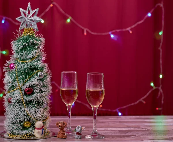 Fondo de Navidad para el año de la rata con un árbol de Navidad artificial ratones de juguete y dos comestibles de champán . —  Fotos de Stock