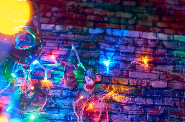 Symbol nového roku. Dvě myši pohled na kameru na jasné vánoční barevné pozadí s girlandy a sklenice šampaňského detailní — Stock fotografie