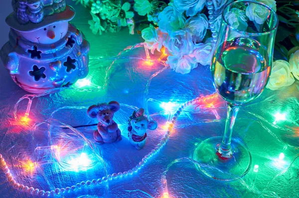Symbol nového roku. Dvě myšky a porcelánový sněhulák ve sněhu s věnci, sklenicí šampaňského a kyticí květin zblízka. — Stock fotografie