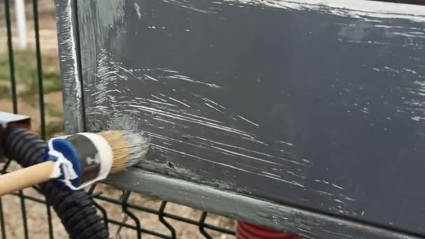曇りの日に灰色の塗料で電気パネルを塗装する — ストック動画