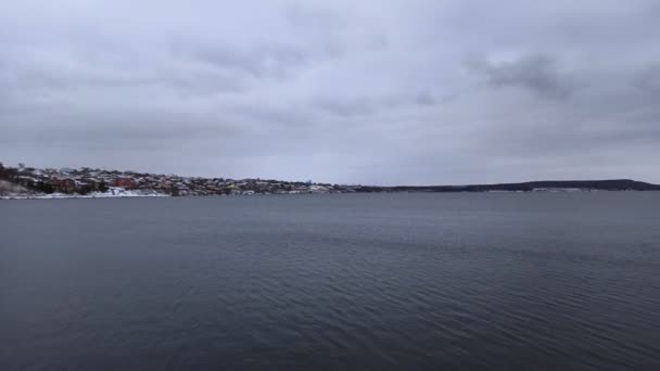 강 과 발전소, 겨울 하늘을 배경으로 해변의 파이프에서 나오는 증기와 바위에 내린 이른 눈. — 비디오