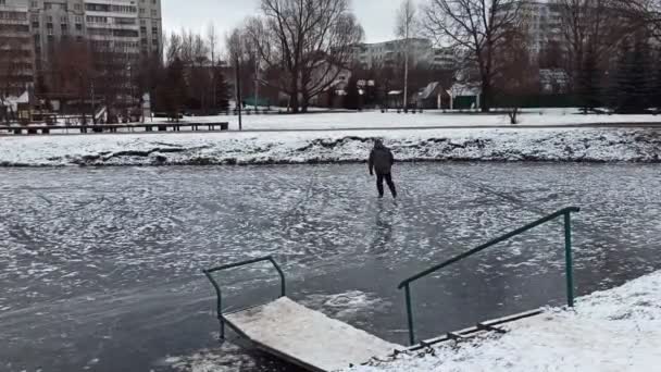 공원에 있는 얼어붙은 연못에서 스케이트를 타는 45 세의 남자. — 비디오