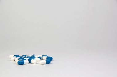 Kısa arkaplanlı mavi ve beyaz haplar. Mesaj için yer var. Biyolojik takviyeler, vitaminler, sağlık ilaçları.
