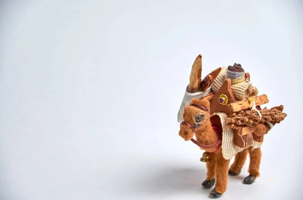 Camelo de brinquedo com uma carga sobre as corcundas close-up em um fundo leve . — Fotografia de Stock