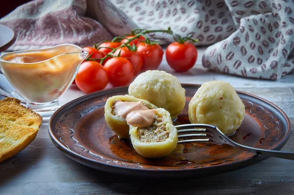 Khinkali ulusal bir Gürcü yemeğidir. Arka planda soslu ve vişneli domatesli kilden bir tabakta. Yakın plan..