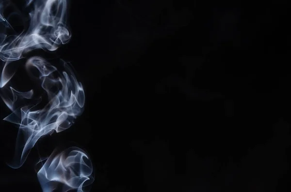 Abstrakt puffar av rök på vänster sida av ramen på en mörk bakgrund med en plats för text, mystik, fantasi — Stockfoto