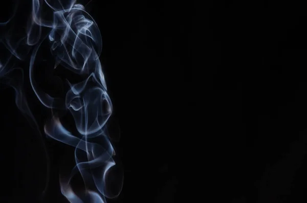 Αφηρημένες εισπνοές καπνού στην αριστερή πλευρά του πλαισίου σε ένα σκοτεινό φόντο με ένα μέρος για κείμενο, μυστικισμό, φαντασία — Φωτογραφία Αρχείου
