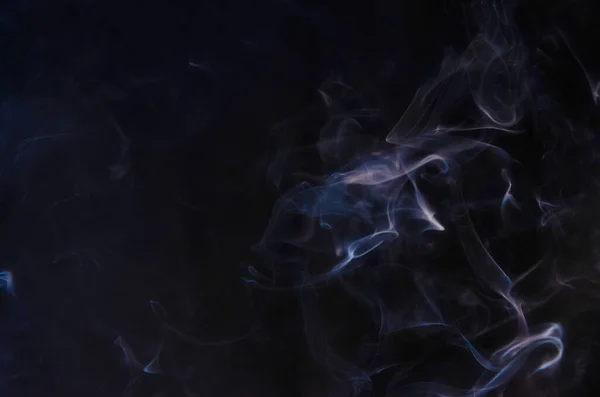 Αφηρημένες εισπνοές καπνού στην αριστερή πλευρά του πλαισίου σε ένα σκοτεινό φόντο με ένα μέρος για κείμενο, μυστικισμό, φαντασία Εικόνα Αρχείου