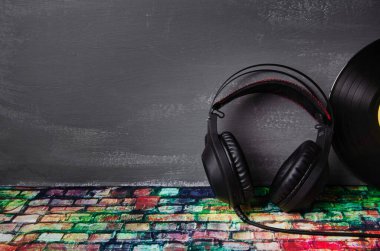 Müzik için kulaklık ve karanlık bir arkaplanda DJ 'in günü için yeri olan bir plak kaydı..
