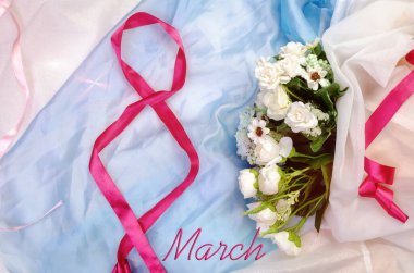 Uluslararası Kadınlar Günü, 8 Mart. 8 numara, havadar saten kumaş arka plandaki kırmızı saten kurdeleden. Çiçek buketi ve pembe incilerle. Üstünde 8 Mart yazılıydı.
