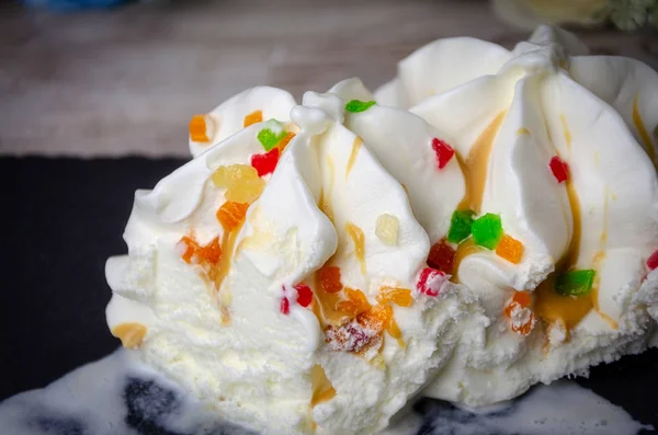 Ice cream ice cream sprinkled with colored pieces of fruit, quench thirst, cool. Macro close up