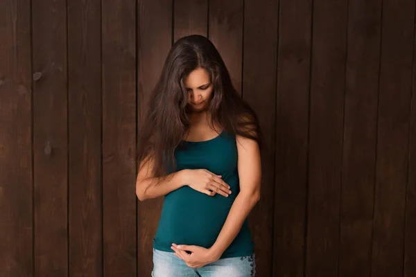 Zwangere Vrouw Jeans Shorts Groene Top Houdt Handen Buik Een — Stockfoto